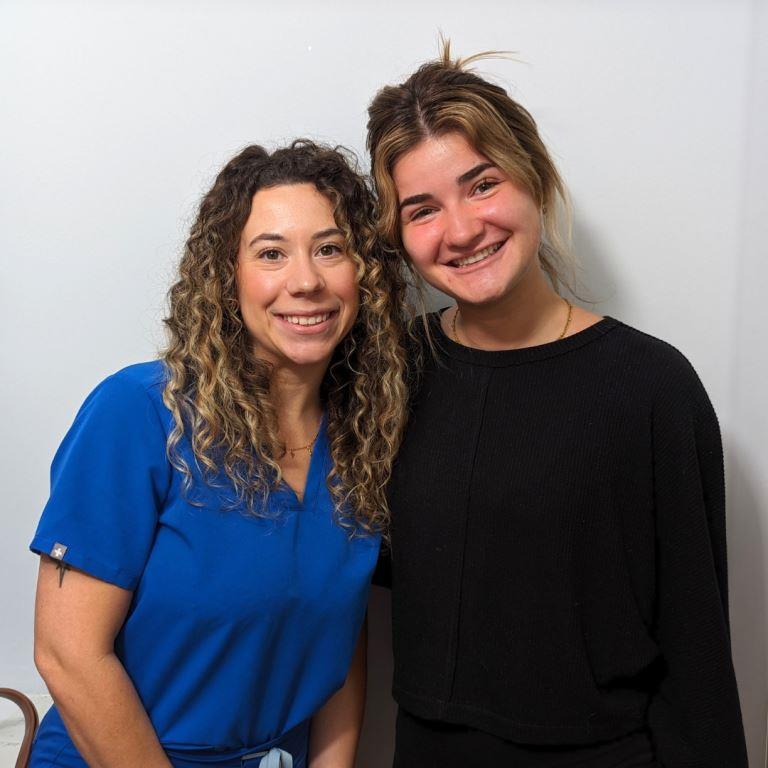 guest Izzy with a team member after treatment