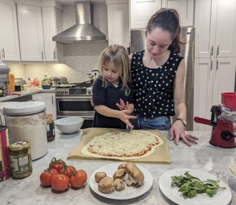 Making pizza with the girls. Adding cheese and toppings.